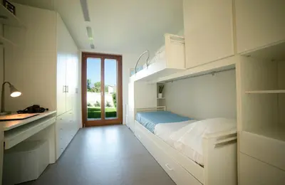 a white bedroom with a bed and a sink in it at Villa Perla del Mare in Alcamo Marina