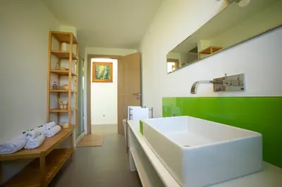 a bathroom with a white sink and green walls at Villa Perla del Mare in Alcamo Marina