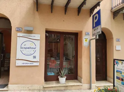 a store with a sign on the side of a building at Residence Mareluna in Castellammare del Golfo