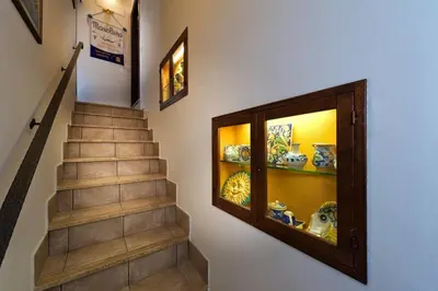 a hallway with a staircase with a glass display case at Residence Mareluna in Castellammare del Golfo