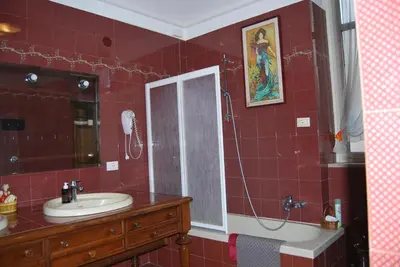 a red tiled bathroom with a sink and a shower at 4You in Palermo