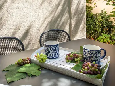 a tray of grapes and two cups on a table at La Casa di Sara a Mondello by Wonderful Italy in Mondello