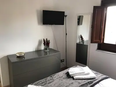 a bedroom with a bed and a tv on the wall at Vista Capo in Palermo