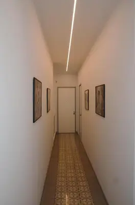 a hallway with paintings on the walls and a door at KMC suites - Yellow in Palermo