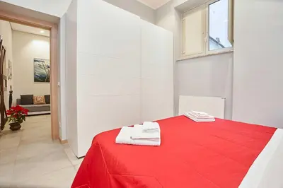 a red bed with two towels on top of it at KMC suites - Red in Palermo