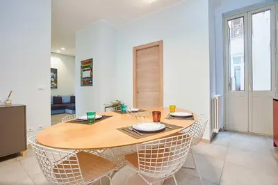 a dining room with a wooden table and chairs at KMC suites - Purple in Palermo