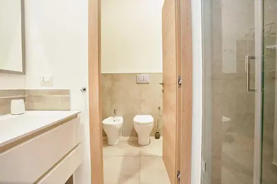 a bathroom with a toilet and a sink at KMC suites - Purple in Palermo