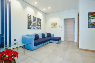 a living room with a blue couch and a glass table at KMC suites - Purple in Palermo