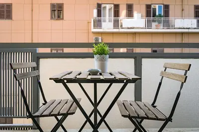 a table with two chairs and a plant on a balcony at Kalamonjo Suite&Rooms in Palermo