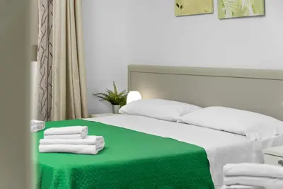 a bed with a green table with towels on it at Casa Francesco in San Vito lo Capo