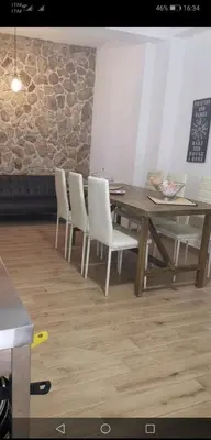 a dining room with a wooden table and white chairs at Villetta Delizia in Scopello