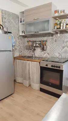 a kitchen with a stove and a refrigerator at Villetta Delizia in Scopello