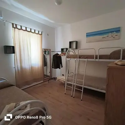 a room with two bunk beds and a window at Villetta Delizia in Scopello