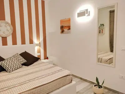a bedroom with a bed and a mirror at Appartamento Le Ginestre in San Vito lo Capo