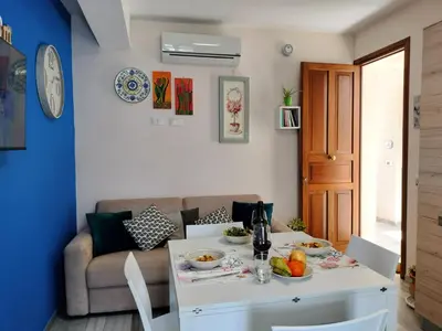 a living room with a table and a couch at Appartamento Le Ginestre in San Vito lo Capo