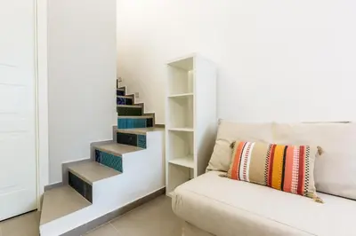 a staircase in a living room with a couch at Loft Piazza Marina Family by DomuSicily in Palermo