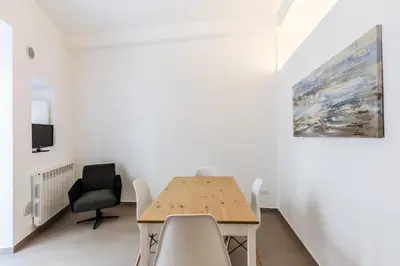 a dining room with a table and chairs and a painting at Loft Piazza Marina Family by DomuSicily in Palermo