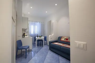 a living room with a couch and a small kitchen at Al Baglio in Castellammare del Golfo