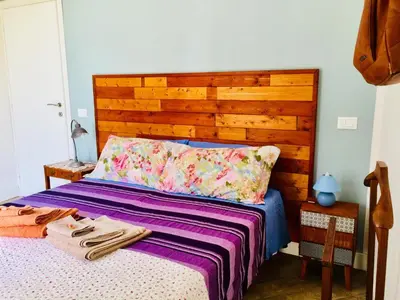 a bedroom with a bed with a wooden headboard at Gò Gò House in Palermo
