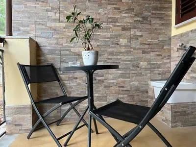 a table and two chairs in front of a brick wall at FUDDIA Room & Suite in Palermo