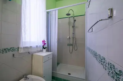 a bathroom with a shower and a toilet and a sink at Mille e una Notte / Station Apartment in Palermo