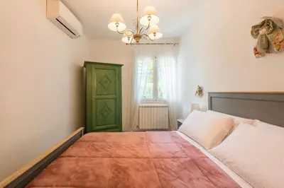 a bedroom with a large bed and a green door at Villa Cinzia-150 mt from the beach in Mondello