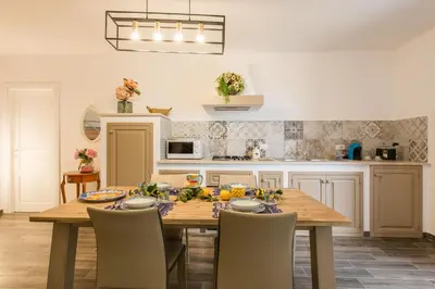 a kitchen with a wooden table with chairs around it at Villa Cinzia-150 mt from the beach in Mondello