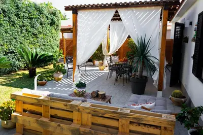 a patio with a white canopy and a couch at Villa Cinzia-150 mt from the beach in Mondello