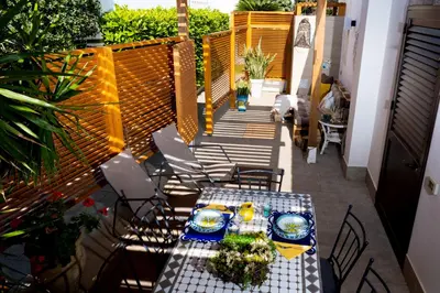 a patio with a table and chairs on a balcony at Villa Cinzia-150 mt from the beach in Mondello