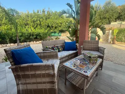 a patio with a couch and chairs and a table at Villa Agapanthus in Castellammare del Golfo