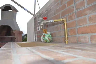 a pipe on the side of a brick wall with a vase at Villa Agapanthus in Castellammare del Golfo