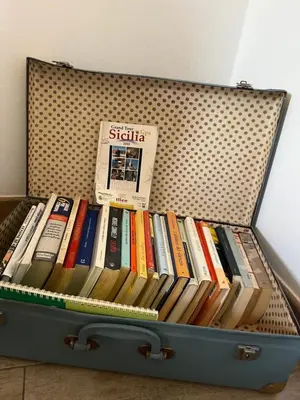 a suitcase full of books sitting on the floor at Villa Agapanthus in Castellammare del Golfo