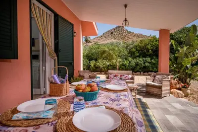 a table and chairs sitting on a patio with a table and chairs at Villa Agapanthus in Castellammare del Golfo