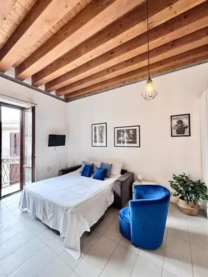 a bedroom with a bed and a blue chair at Capo Loft in Palermo