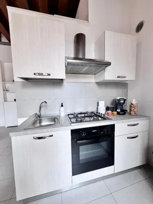 a kitchen with white cabinets and a stove and a sink at Capo Loft in Palermo