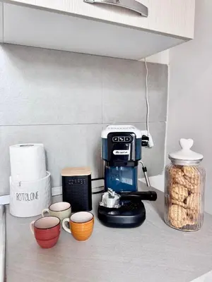 a coffee maker on a kitchen counter with cups at Capo Loft in Palermo