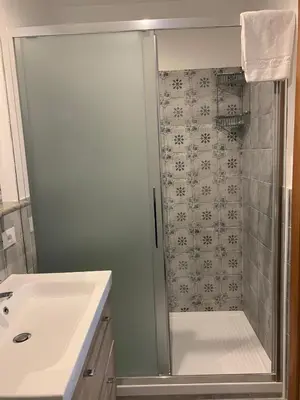 a shower with a glass door next to a sink at Hotel Villa Archirafi in Palermo