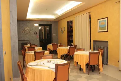 a dining room with tables and chairs with yellow walls at Hotel Villa Archirafi in Palermo