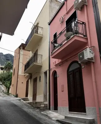 a pink building with balconies on the side of a street at Casa di Cecilia in Castellammare del Golfo