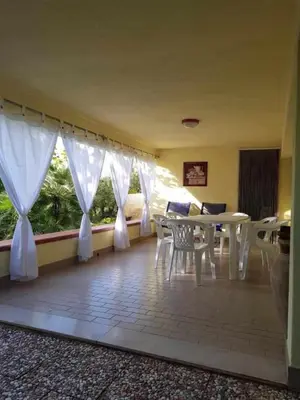 a living room with a table and chairs and a window at Casa Rosalba in San Vito lo Capo