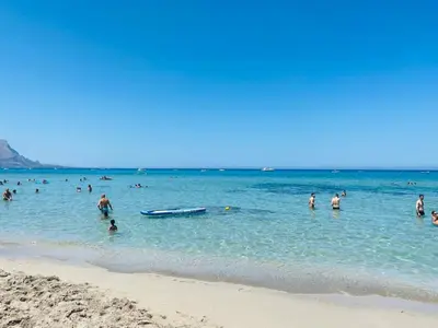a group of people in the water at the beach at casa delle rose in Isola delle Femmine