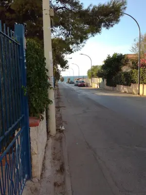 a blue fence on the side of a street at casa delle rose in Isola delle Femmine