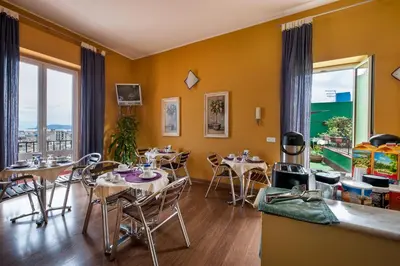 a dining room with tables and chairs and windows at Sky Sleeping in Palermo