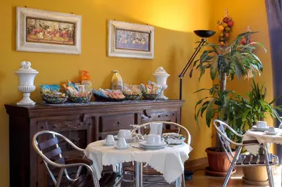 a table and chairs with dishes on top of a cabinet at Sky Sleeping in Palermo