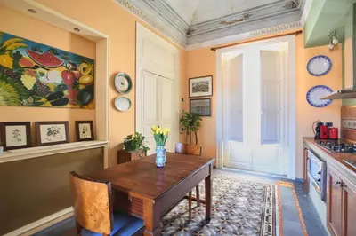 a kitchen with a wooden table and a window at Al Massimo Piacere in Palermo