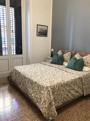 a bedroom with a large bed with green pillows at La Bella Balla-rò Rooms in Palermo