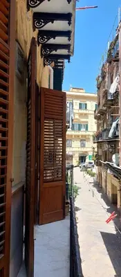 a building with a wooden door on a street at David house alla Vucciria in Palermo
