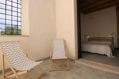 two rocking chairs and a bed in a room at Antico Baglio Siciliano in Balestrate
