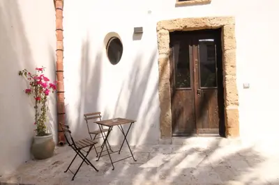 a table and chairs sitting in front of a door at Antico Baglio Siciliano in Balestrate