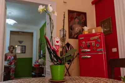 a kitchen with a red refrigerator and a green vase with flowers at Nuovo Cortile Palermo Bed and Breakfast in Palermo